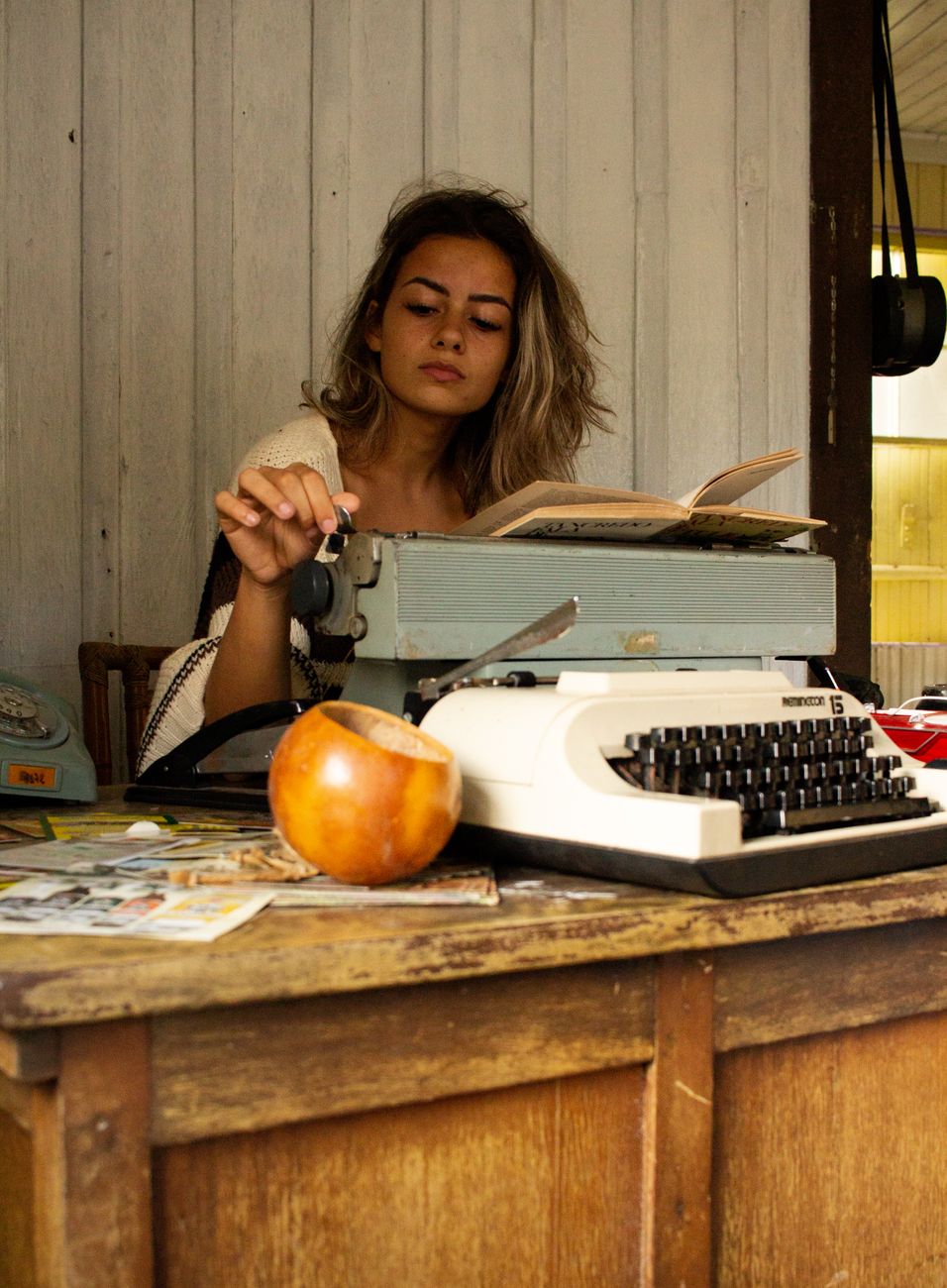Editorial travel writer sitting in rustic wooden workspace reviewing notes